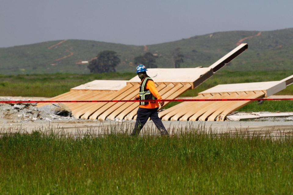 Un trabajador de la construcción caminando junto a un prototipo del muro propuesto por el presidente de los Estados Unidos, Donald Trump, que fue demolido para dar paso a una nueva sección de vallas fronterizas cerca de San Diego, California, el 27 de febrero de 2019. REUTERS/Jorge Duenes