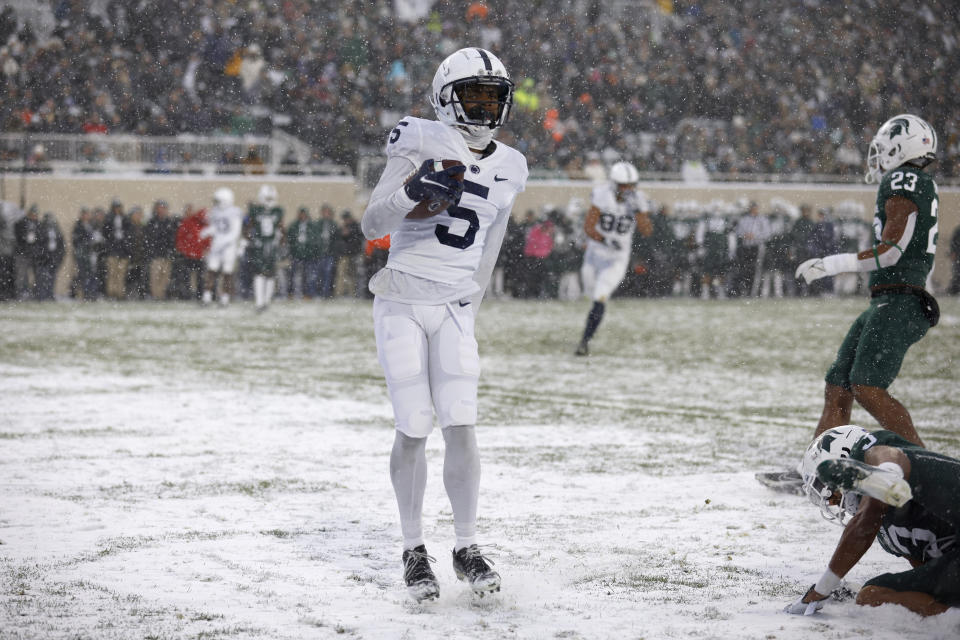 Penn State receiver Jahan Dotson (5) scores a touchdown against Michigan State's Xavier Henderson, bottom right, and Darius Snow (23) during the first half of an NCAA college football game, Saturday, Nov. 27, 2021, in East Lansing, Mich. (AP Photo/Al Goldis)