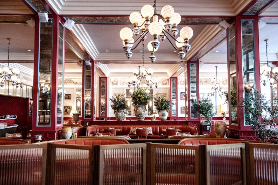 A globe chandelier hangs above red leather banquettes.