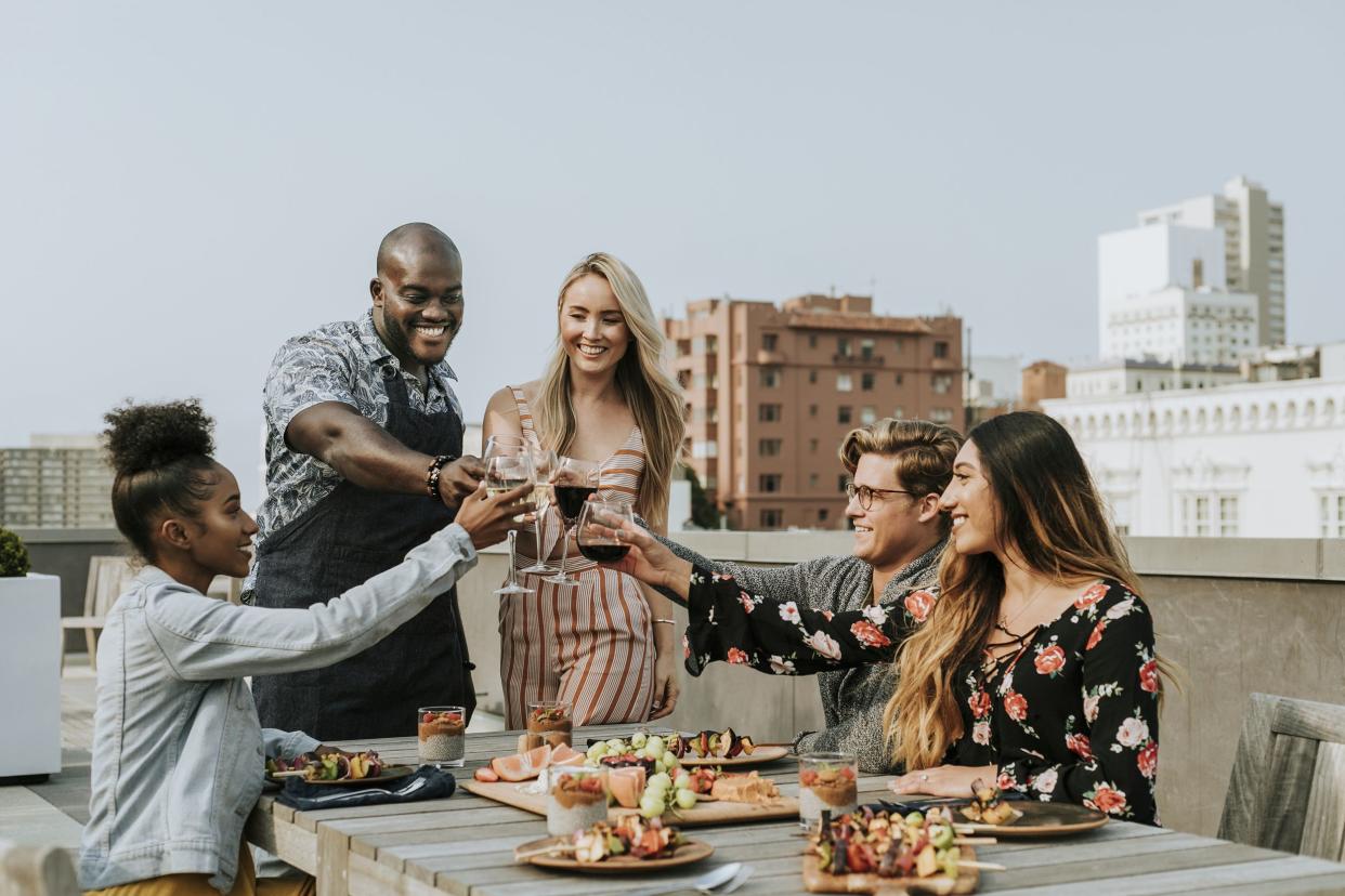cheerful friends toasting at a rooftop party in San Francisco, California