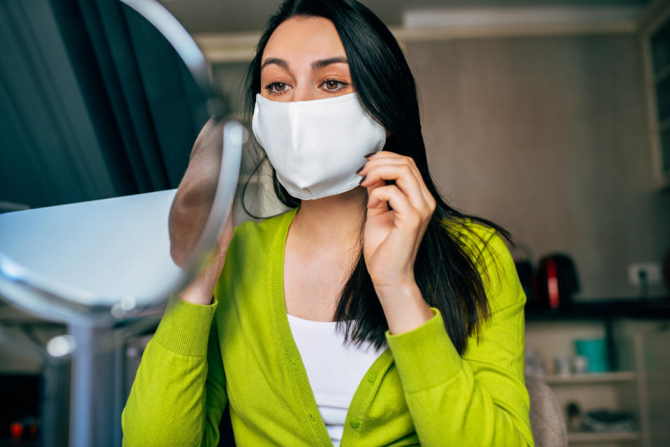 Image of woman blogger wearing mask during quarantine, creating new content for her blog on social networks. Female wears mask to protect from virus. Coronavirus, internet, blogging.