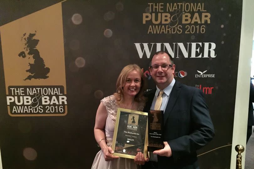 Two people holding an award