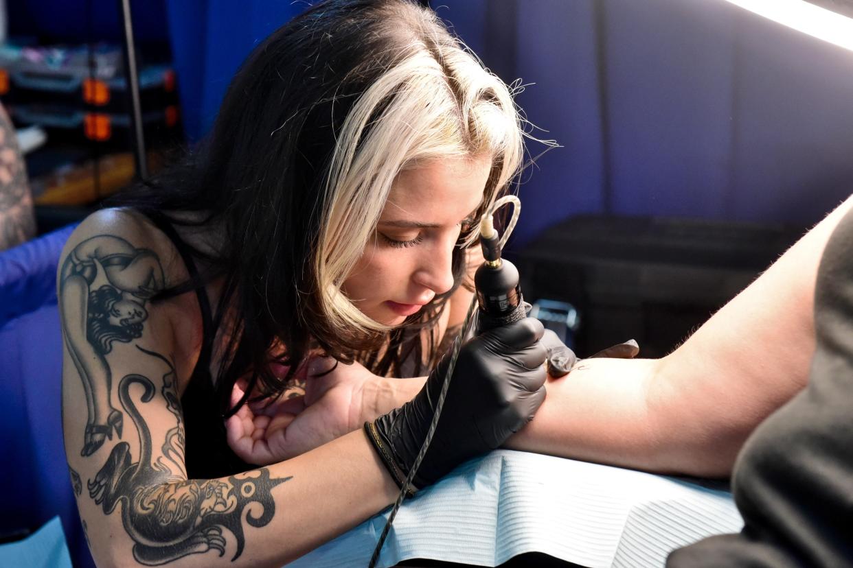 Ari Mastellino, a tattoo artist with Foundation Tattoo in Pittsburgh, works on a tattoo during the 2023 INKcarceration Music & Tattoo Festival.