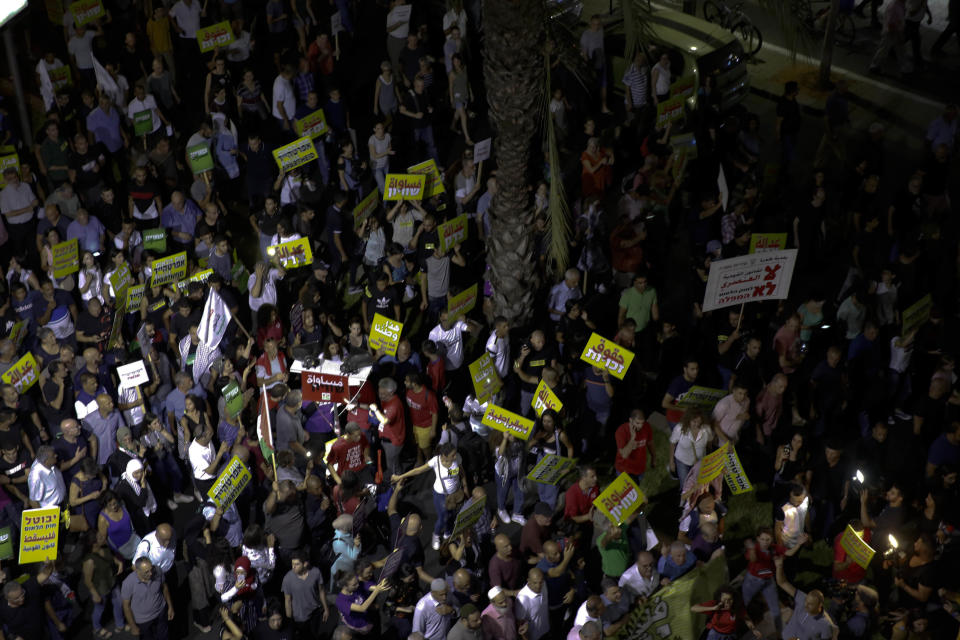 People march during a protest against the Jewish nation bill in Tel Aviv, Israel, Saturday, Aug. 11, 2018. The recently passed law that enshrines Israel's Jewish character and downgrades the standing of Arabic from an official to a "special" language. (AP Photo/Ariel Schalit)