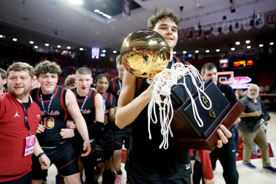 Owasso's Jalen Montonati carries the trophy after the Class 6A boys high school basketball state tournament championship game between Edmond North and Owasso at Lloyd Noble Center in Norman, Okla., Saturday, March 9, 2024.