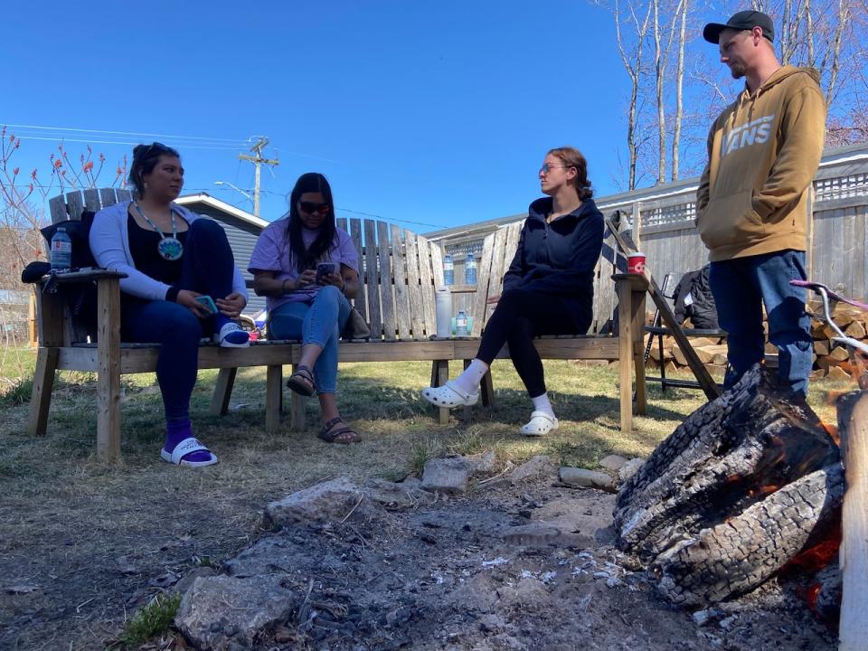 Relatives of Sheri Lynn Sabattis sit and talk around a sacred fire that was lit in her memory at a home in Oromocto First Nation. Pictured from left are Dymond Sabattis, Desirae Sabattis, Kyla Sabattis and Aubrey Landry.