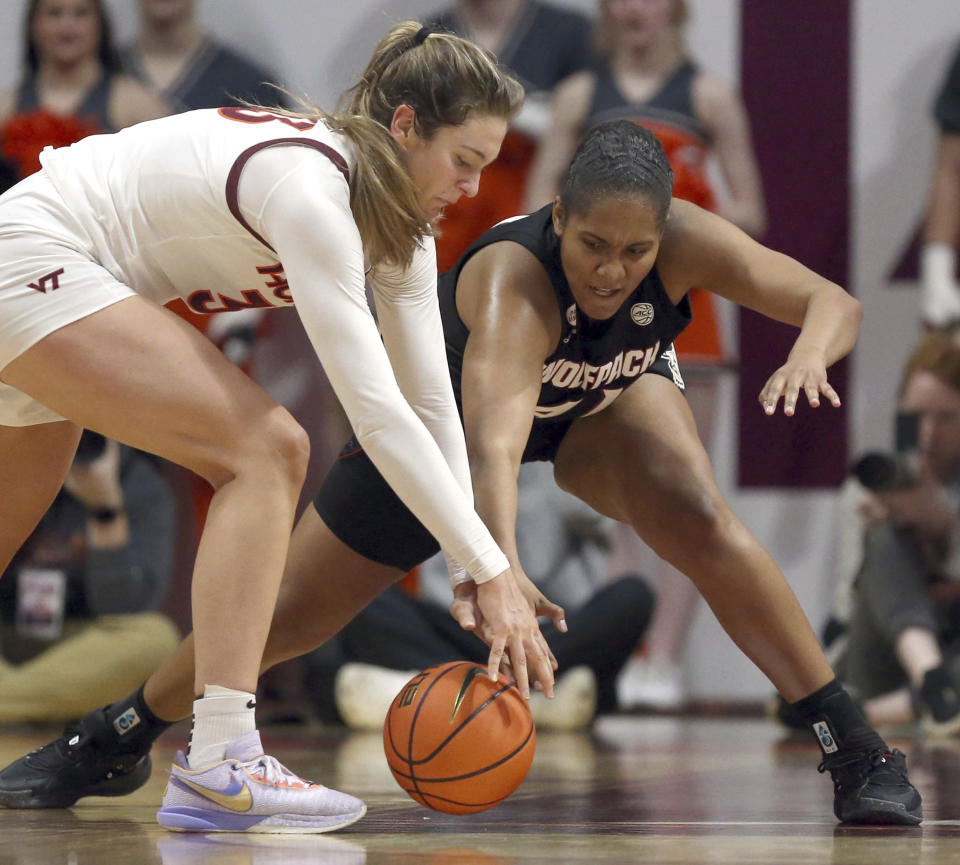 Virginia Tech's Elizabeth Kitley (33) left, and North Carolina State's Camille Hobby (41) reach for the ball during the first half of an NCAA college basketball game Sunday, Feb. 19, 2023, in Blacksburg, Va. (Matt Gentry/The Roanoke Times via AP)