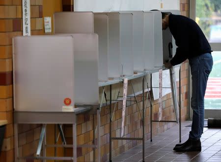 A man fills out his ballot for a national election at a polling station in Tokyo, Japan October 22, 2017. EUTERS/Kim Kyung-Hoon