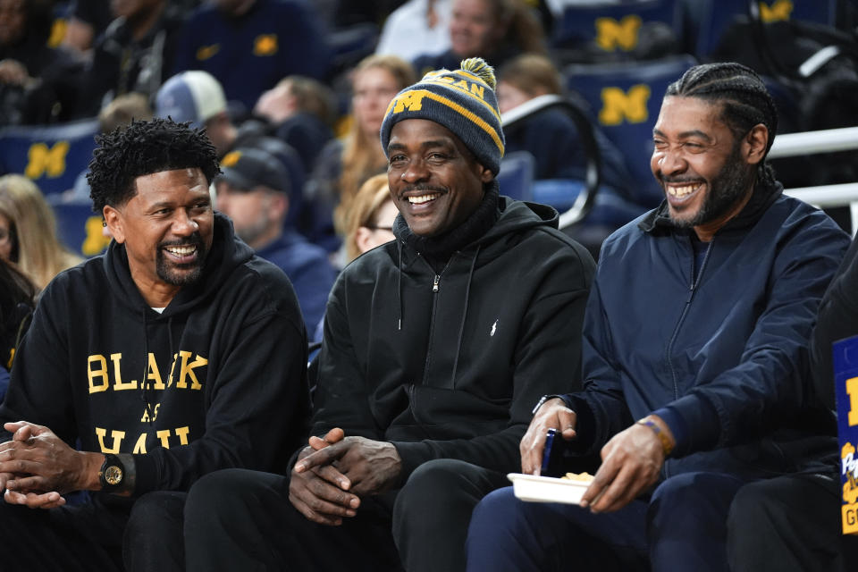 Former Fab Five Michigan basketball players Jalen Rose, from left, Chris Webber and Jimmy King smile in the second half of an NCAA college basketball game against Ohio State in Ann Arbor, Mich., Monday, Jan. 15, 2024. (AP Photo/Paul Sancya)