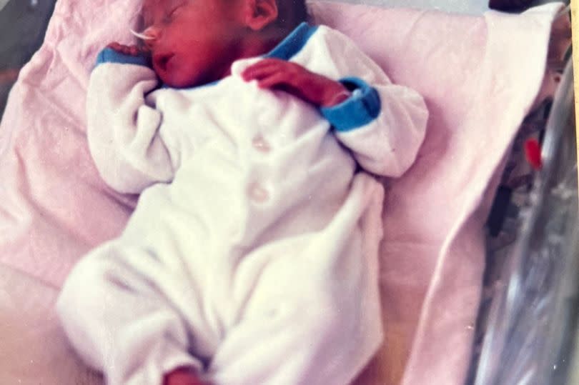 Stuart as a tiny baby - lying in a cot