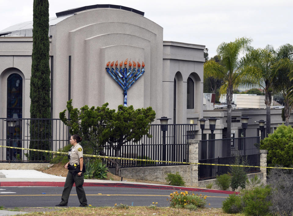 FILE - In this Sunday, April 28, 2019 file photo, a San Diego county sheriff's deputy stands in front of the Poway Chabad Synagogue in Poway, Calif. Prosecutors say John T. Earnest opened fire during a Passover service at the synagogue on April 27, killing one woman and injuring three people, including the rabbi. A preliminary hearing for Earnest begins Thursday, Sept. 18, 2019, in state court and is expected to last up to two days. (AP Photo/Denis Poroy, File)