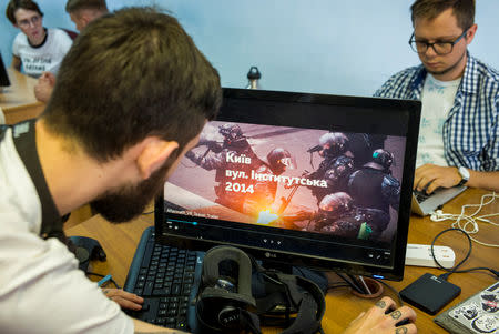 Staff members of the New Cave Media test a simulator of virtual reality of the 2013/2014 demonstration in Ukraine, when dozens of protesters were killed in the final moments of Viktor Yanukovich's rule, in their office in Kiev, Ukraine September 11, 2018. REUTERS/Gleb Garanich