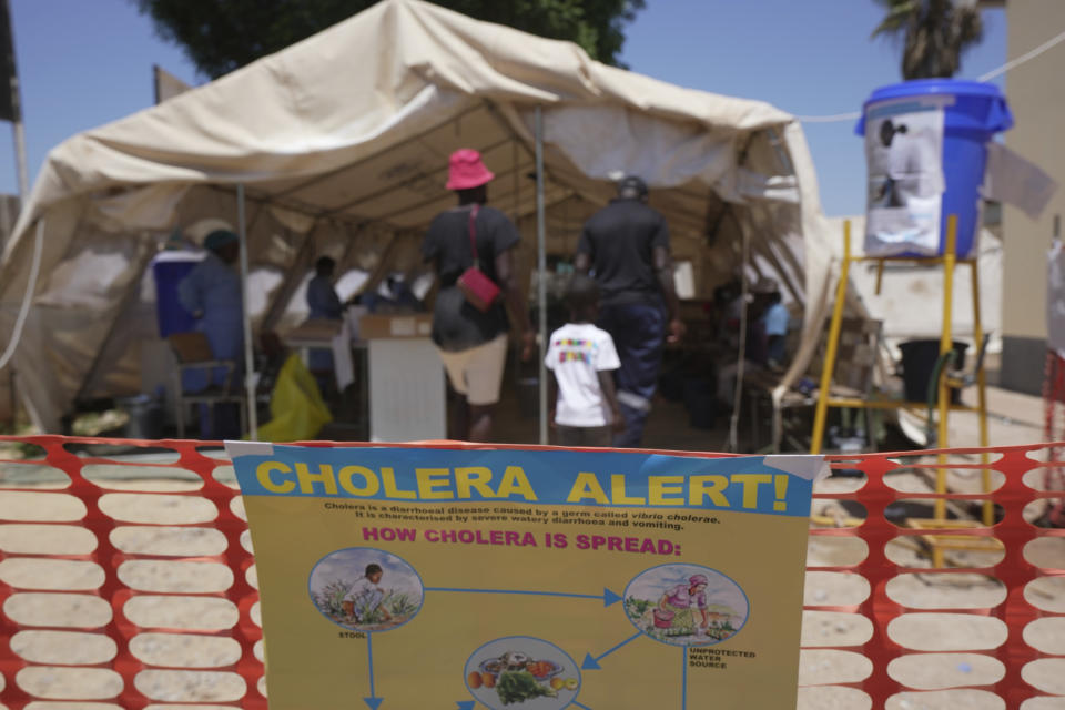 A family is seen entering a tent set aside for cholera patients at a clinic in Harare, Zimbabwe, Saturday Nov. 18, 2023. Zimbabwe is battling a cholera outbreak that has resulted in more than 150 suspected deaths countrywide. Health experts, authorities and residents blame the outbreak on acute water shortages and lack of access to sanitation and hygiene services (AP Photo/Tsvangirayi Mukwazhi)