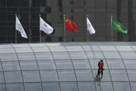 A worker descends on the rooftop of a building at the central business district in Beijing, China, Monday, July 15, 2024. China's ruling Communist Party is starting a four-day meeting Monday that is expected to lay out a strategy for self-sufficient economic growth in an era of heightened national security concerns and restrictions on access to American technology. (AP Photo/Vincent Thian)