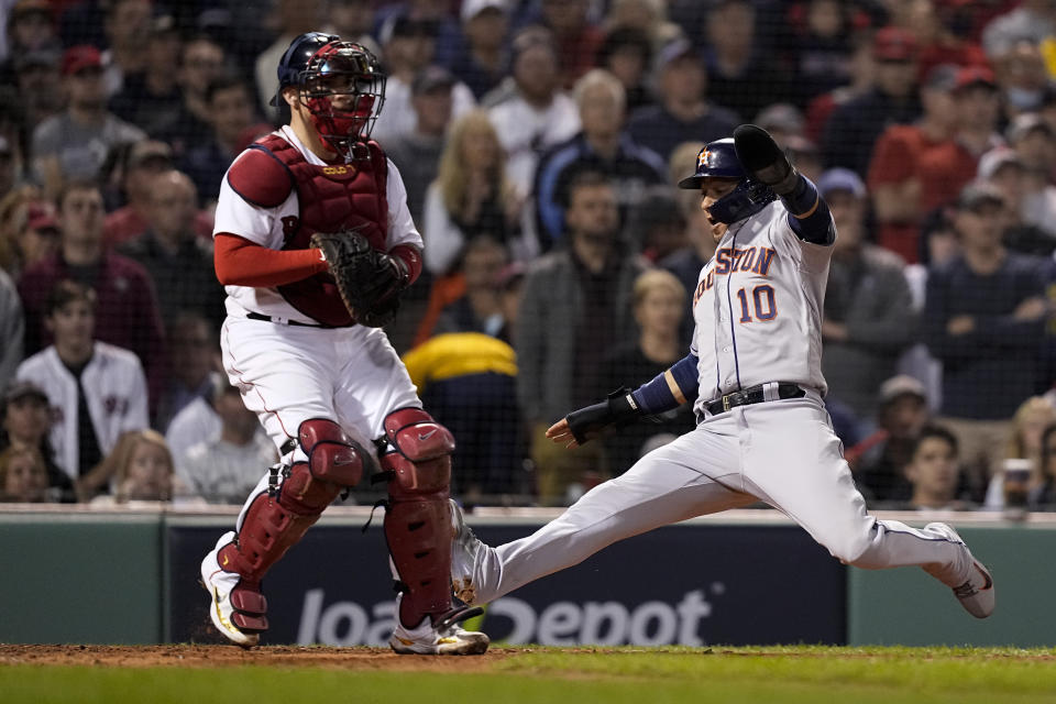 Houston Astros' Yuli Gurriel scores past Boston Red Sox catcher Christian Vazquez on a hit by Jose Siri during the sixth inning in Game 5 of baseball's American League Championship Series Wednesday, Oct. 20, 2021, in Boston. (AP Photo/David J. Phillip)