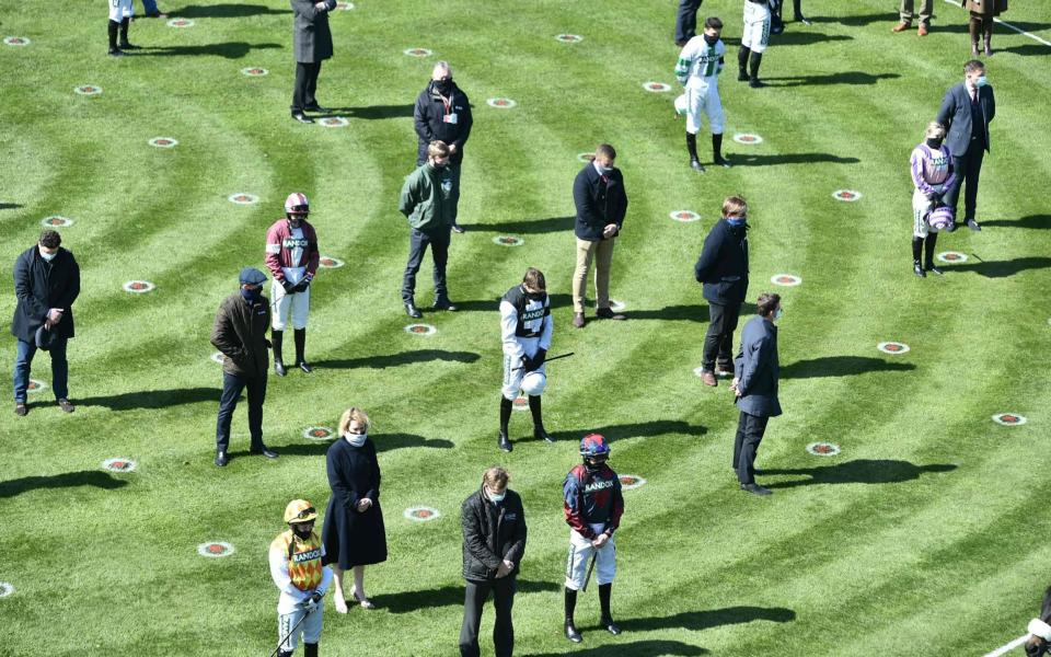Jockeys and trainers pay their respects at Aintree on Friday - AFP