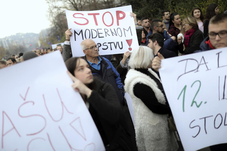 A man holds a banner that reads "Stop Modern Slavery" during a protest joined by up to a thousand people in Sarajevo, Bosnia, Thursday, Nov. 21, 2019. Protesters in Bosnia have rallied outside the government building in Sarajevo after opposition lawmaker Sabina Cudic published shocking photos of special needs children tied to beds and radiators in a nearby government facility. The protest Thursday by 1,000 people included scores of parents of children with disabilities, who described a dysfunctional care system that condemns their kids to suffering and excludes them from society. (AP Photo/Almir Alic)