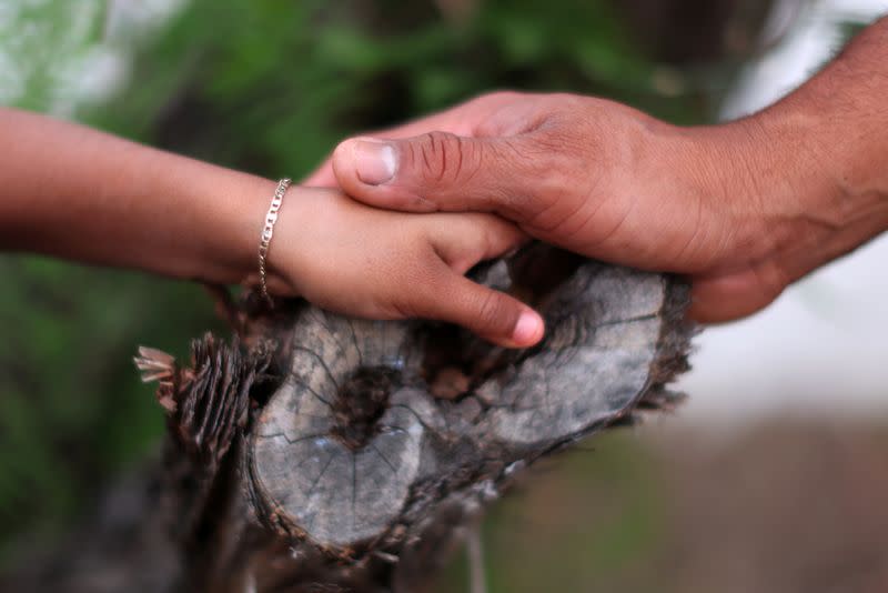 Maynor, 32, holds his daughter’s hand at his home in Los Angeles