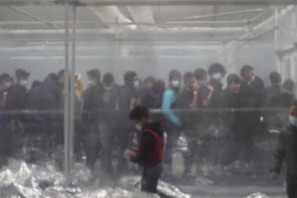 Teenage boys held at the Donna tent facility line up to collect juice and snacks. / Credit: TV Pool