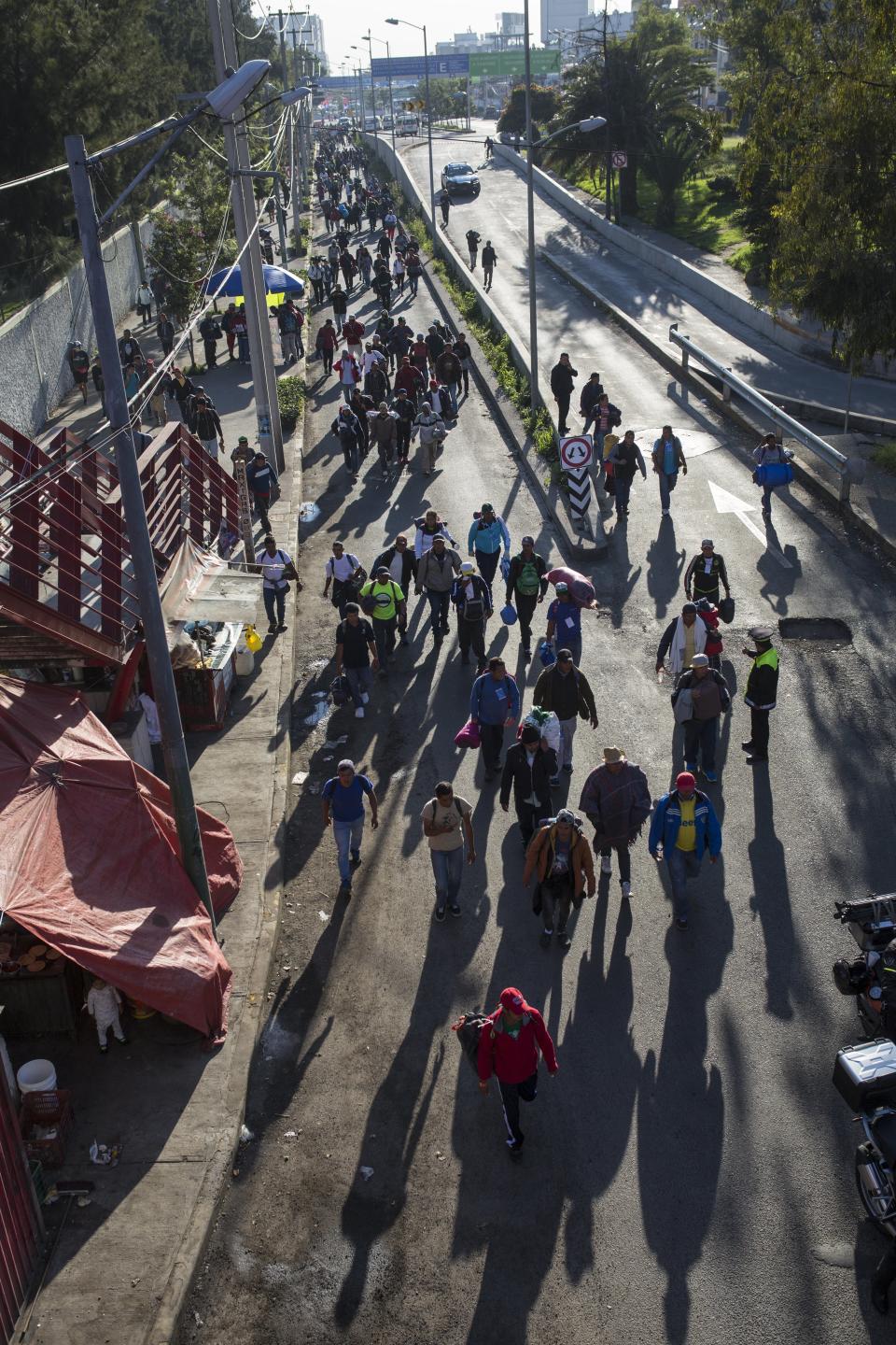 A group of Central American migrants resume their journey north after leaving the temporary shelter at the Jesus Martinez stadium, in Mexico City, Friday, Nov. 9, 2018. About 500 Central American migrants headed out of Mexico City on Friday to embark on the longest and most dangerous leg of their journey to the U.S. border, while thousands more were waiting one day more at the stadium. (AP Photo/Rodrigo Abd)