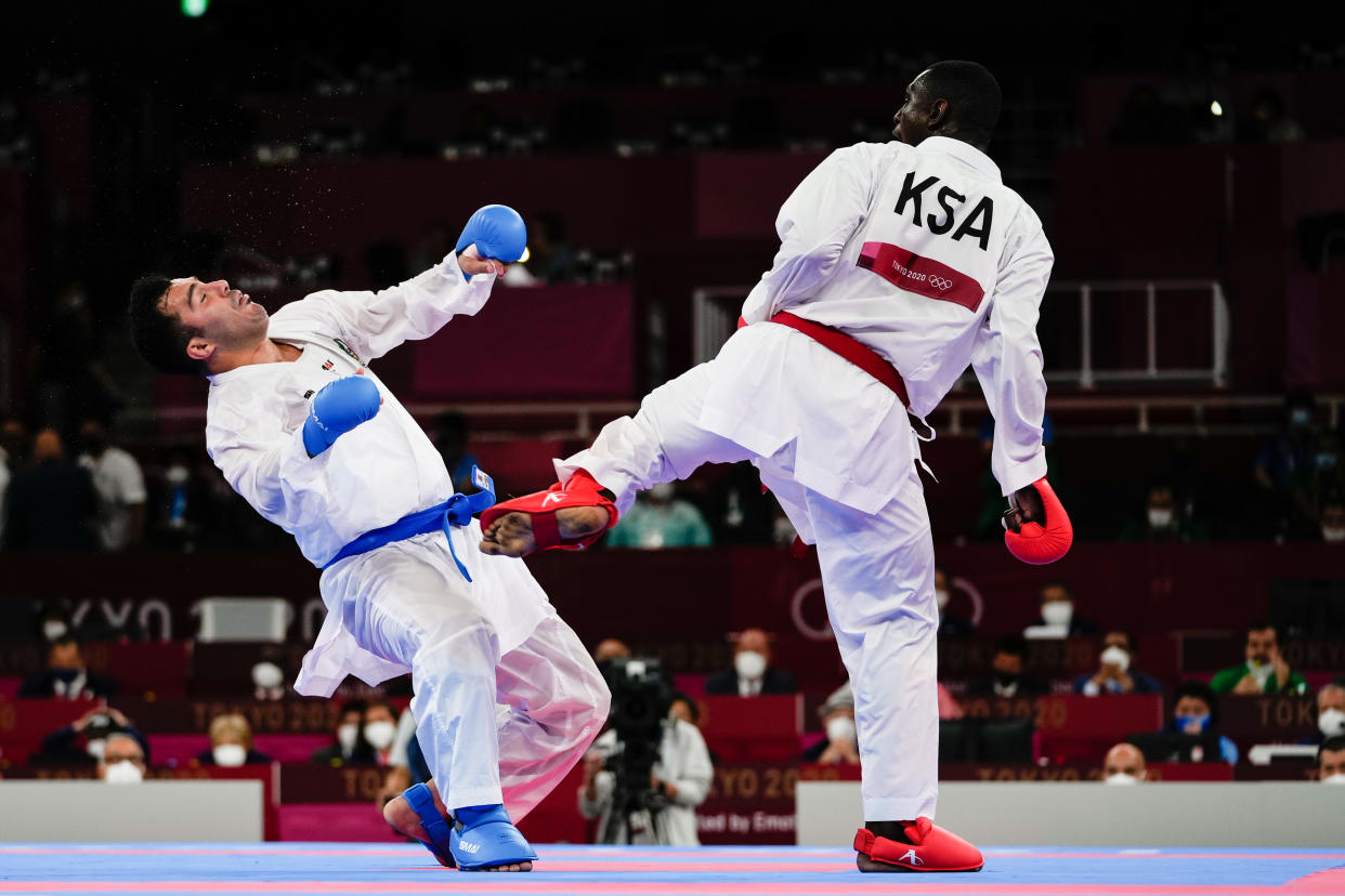 TOKYO, JAPAN - AUGUST 07: Sajad Ganjzadeh (L) of Team Iran gets injured as he competes against Tareg Hamedi of Team Saudi Arabia during the Men's Karate Kumite +75kg Gold Medal Bout on day fifteen of the Tokyo 2020 Olympic Games at Nippon Budokan on August 7, 2021 in Tokyo, Japan. (Photo by Wei Zheng/CHINASPORTS/VCG via Getty Images)