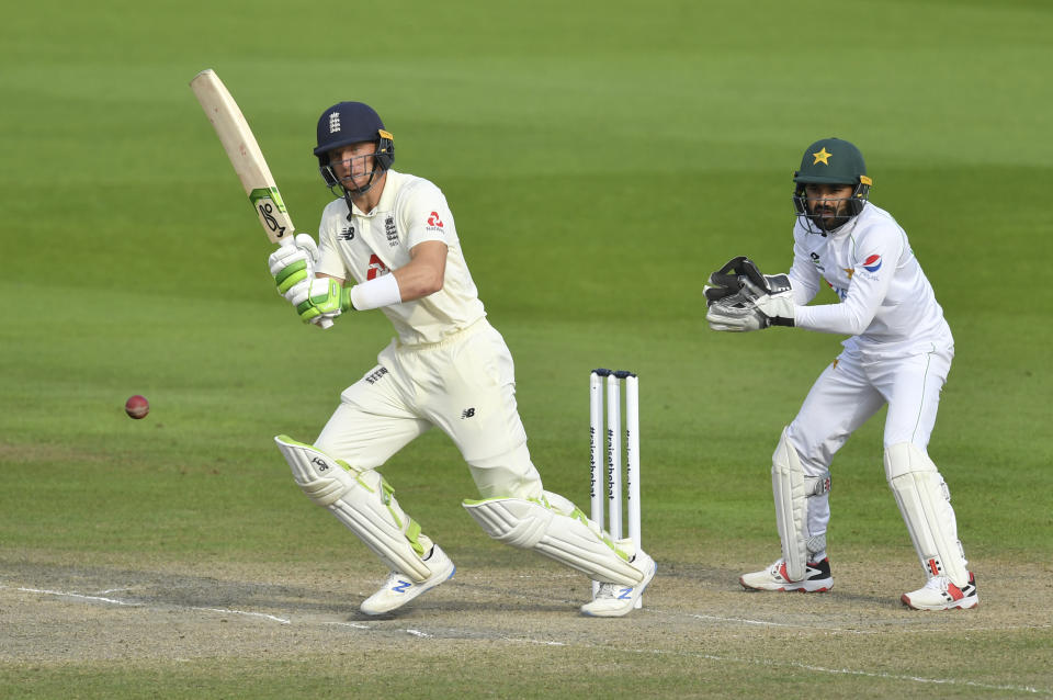 England's Jos Buttler, left, plays a shot during the fourth day of the first cricket Test match between England and Pakistan at Old Trafford in Manchester, England, Saturday, Aug. 8, 2020. (Dan Mullan/Pool via AP)