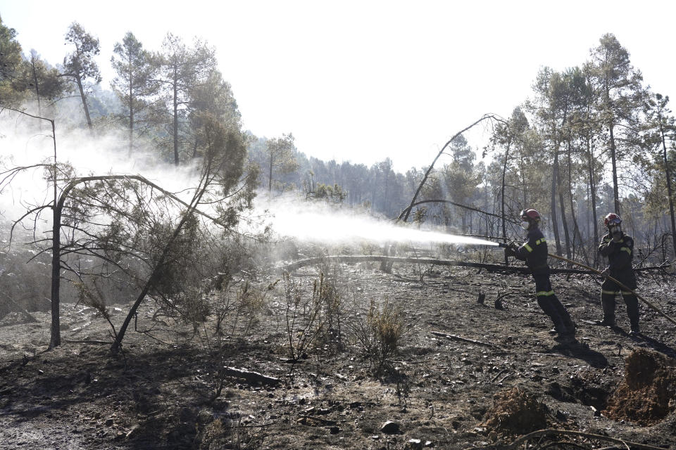 Firefighters try to extinguish a forest fire in Fuente la Reina, Castellon de la Plana, Spain, March 29, 2023. A prolonged drought after a record-hot 2022 appears to have brought the wildfire season forward and Spanish officials are now bracing for more huge fires. (AP Photo/Alberto Saiz)