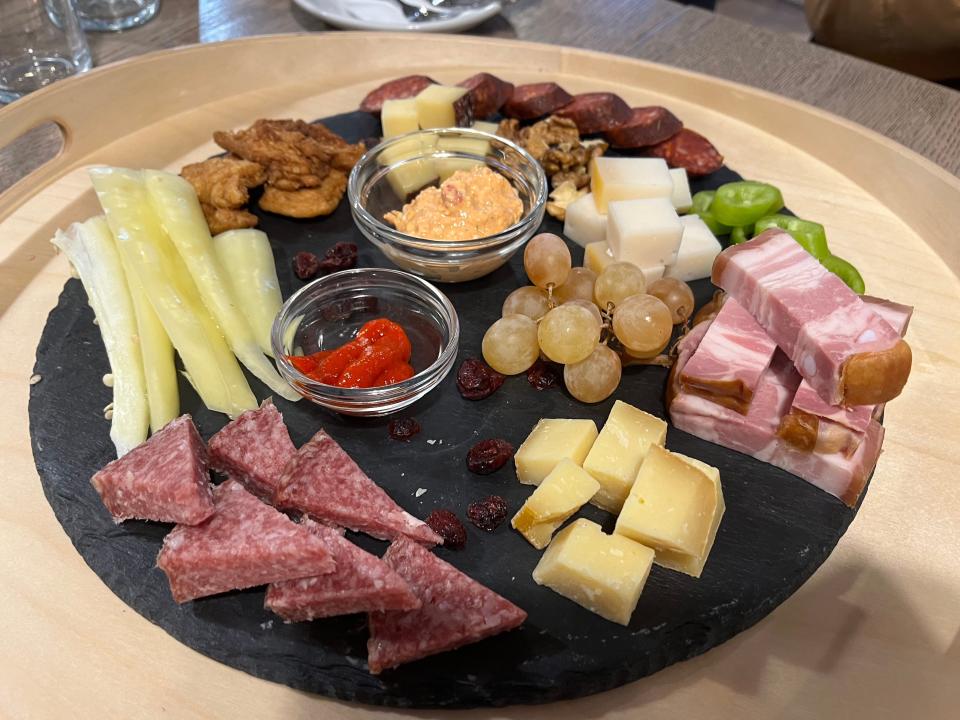 charcuterie plate full of meats, cheeses, fruits, and sauces
