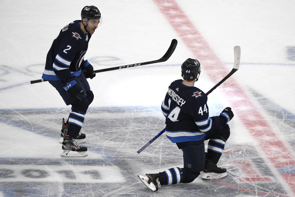 Winnipeg Jets' Josh Morrissey (44) celebrates his goal with teammate Dylan DeMelo (2) during the third period of an NHL hockey Stanley Cup playoff game, Sunday, May 23, 2021, in Winnipeg, Manitoba. (Fred Greenslade/The Canadian Press via AP)