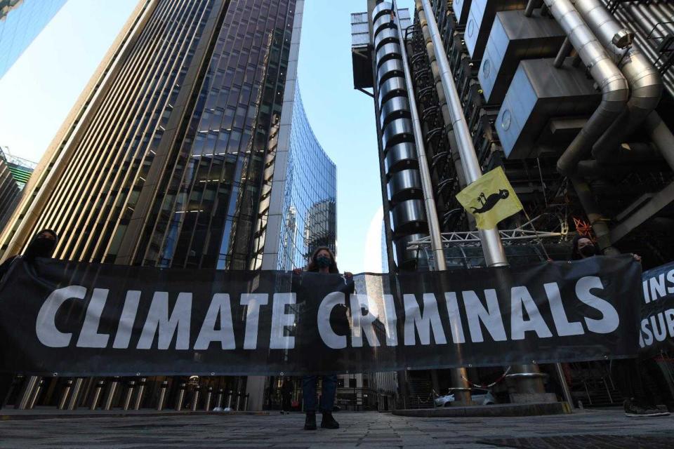 An activist stands next to a ‘climate criminals’ banner outside Lloyd’sGareth Morris