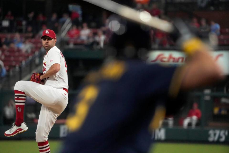 St. Louis Cardinals starting pitcher Adam Wainwright throws as Milwaukee Brewers’ Josh Donaldson, right, warms up in the on-deck circle during the second inning of a baseball game Monday, Sept. 18, 2023, in St. Louis. (AP Photo/Jeff Roberson)