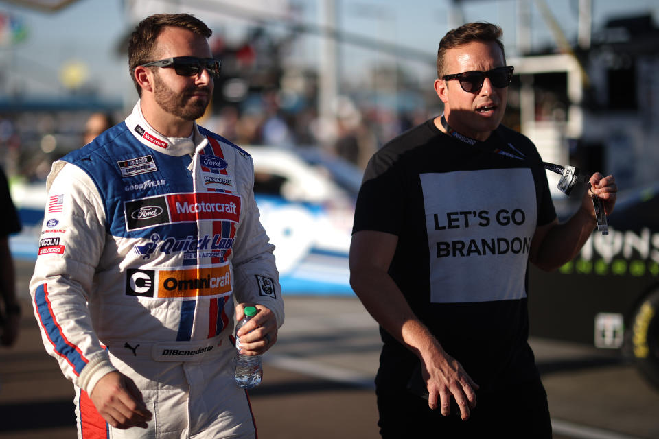 AVONDALE, ARIZONA - NOVEMBER 06: Matt DiBenedetto, driver of the #21 Motorcraft/Quick Lane Ford, walks on the grid with 
 a fan during qualifying for the NASCAR Cup Series Championship at Phoenix Raceway on November 06, 2021 in Avondale, Arizona. (Photo by Chris Graythen/Getty Images)