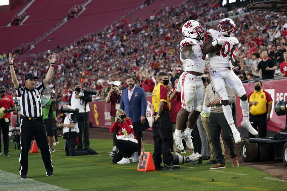 Utah wide receiver Money Parks (10) celebrates his touchdown reception with running back TJ Pledger during the first half of the team's NCAA college football game against Southern California on Saturday, Oct. 9, 2021, in Los Angeles. (AP Photo/Marcio Jose Sanchez)