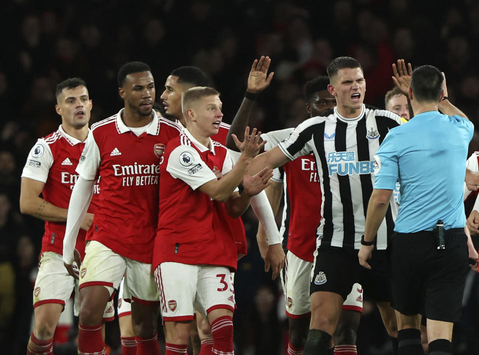 Referee Andy Madley discusses with players during the English Premier League soccer match between Arsenal and Newcastle United at Emirates stadium in London, Tuesday, Jan. 3, 2023. (AP Photo/Ian Walton)