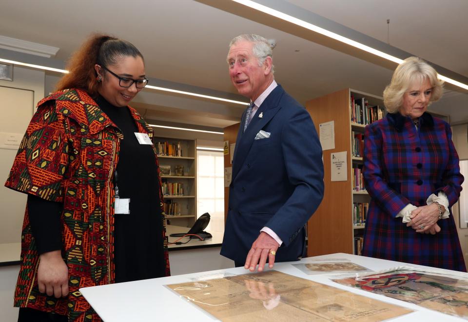 LONDON, ENGLAND - FEBRUARY 16: Prince Charles, The Prince of Wales and the Camilla, Duchess of Cornwall are shown items of historical significance by Natalie Fiawoo (left) during their visit to the Black Cultural Archives in Brixton on February 16, 2017 in London, England.  (Photo by Jonathan Brady / WPA Pool - Getty Images)