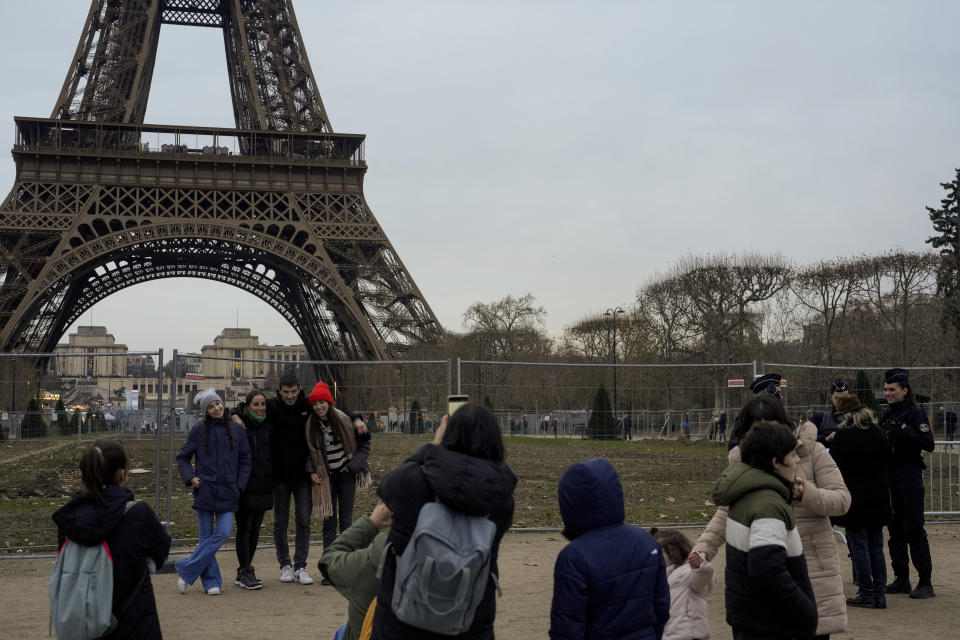 French policemen, right, patrol around the Eiffel Tower, in Paris, Thursday, Dec. 7, 2023. Less than a year before the 2024 Paris Olympic Games, with an opening ceremony on the nearby Seine river, the bar was already high. But the security challenge went up with the deadly weekend knife attack that killed a tourist near the Eiffel Tower, a tourist magnet that is the symbol of Paris. (AP Photo/Thibault Camus)
