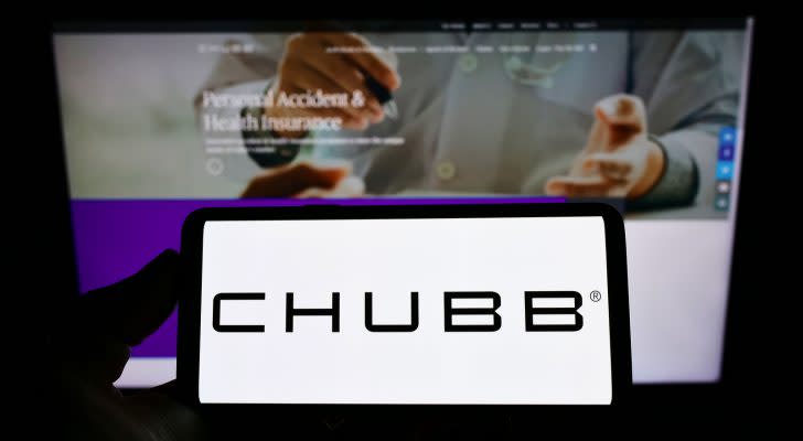 Person holding cellphone with logo of Swiss insurance company Chubb Limited on screen in front of business webpage. CB stock.