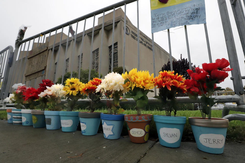 Flower pots, each with a name of one of the 11 worshippers killed on Oct. 27, 2018, when a gunman opened fire as worship services began at the Tree of Life Synagogue, line the fence surrounding the synagogue on Saturday, Oct. 26, 2019, in the Squirrel Hill neighborhood of Pittsburgh. The first anniversary of the deadly shooting at the synagogue is Sunday, Oct., 27. (AP Photo/Gene J. Puskar)