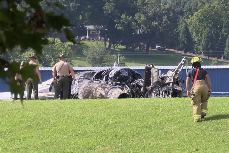 The burned remains of a plane that was carrying NASCAR television analyst and former driver Dale Earnhardt Jr. lies near a runway Thursday, Aug. 15, 2019, in Elizabethton, Tenn. Officials said the Cessna Citation rolled off the end of a runway and caught fire after landing at Elizabethton Municipal Airport. Earnhardt's sister, Kelley Earnhardt Miller, tweeted that "everyone is safe and has been taken to the hospital for further evaluation." (WJHL TV via AP)