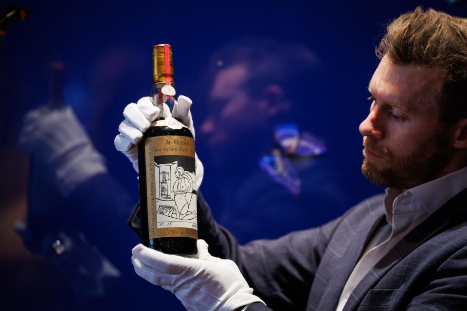 Jonny Fowle, Sotheby's Global Head of Spirits, unveils a bottle of The Macallan 1926, the world's most expensive whisky estimated at £750,000- 1,200,000, at Sotheby's on October 19, 2023 in London, England.