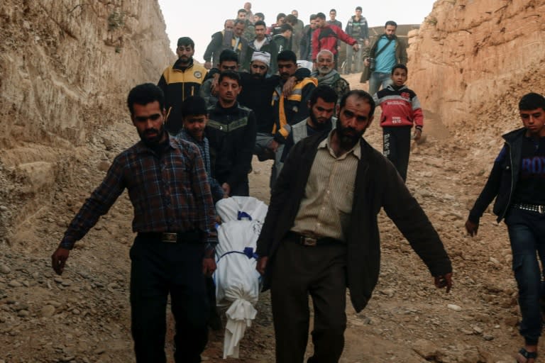 Syrians carry for burial the bodies of victims who died following reported shelling by Syrian government forces in the rebel-held town of Douma in eastern Syria. The conflict has claimed over 300,000 lives