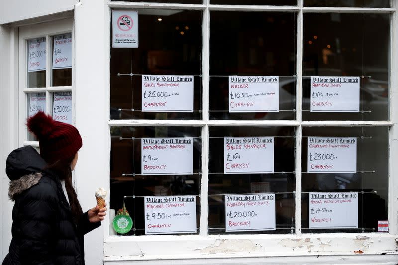 FILE PHOTO: A person looks at advertisements in the window of a job agency in London