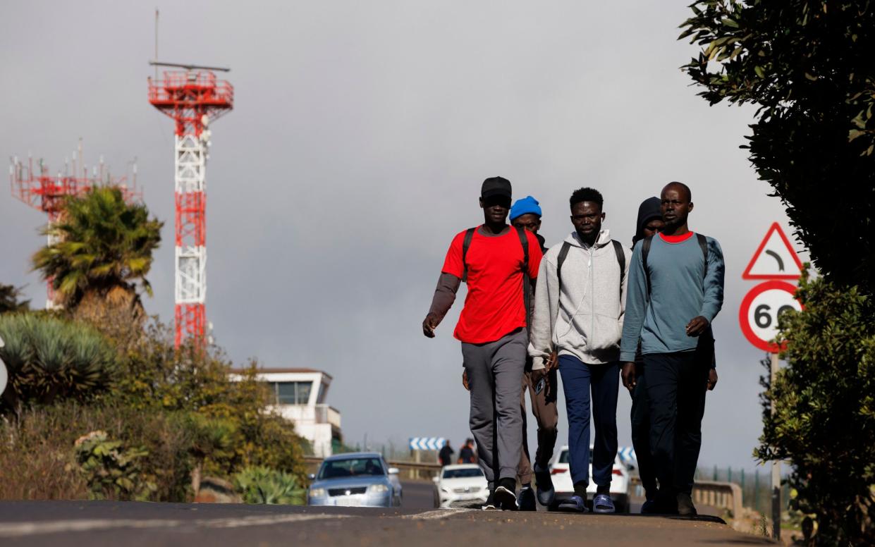 Migrants walk from the Centro de inmigrantes