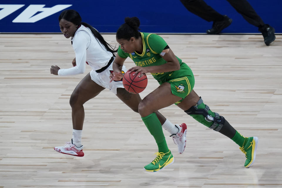 Oregon forward Nyara Sabally, right, drives up court past Louisville guard Dana Evans, left, during the first half of a college basketball game in the Sweet Sixteen round of the women's NCAA tournament at the Alamodome in San Antonio, Sunday, March 28, 2021. (AP Photo/Eric Gay)