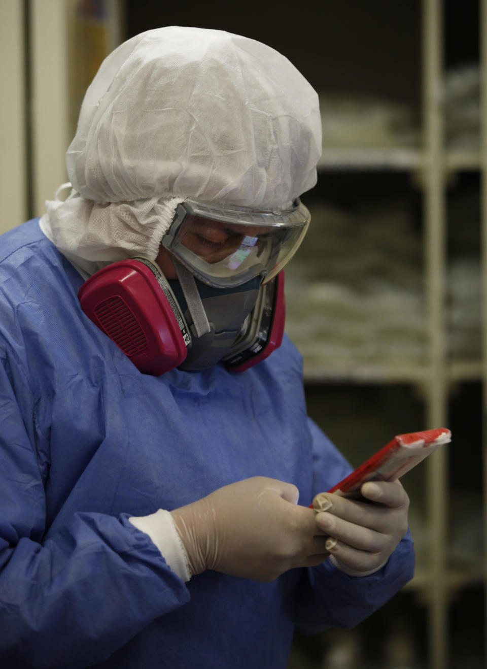 Una trabajadora de salud cubierta con equipo de protección completo contra la propagación del nuevo coronavirus chatea en su teléfono móvil dentro de la sala COVID-19 del Hospital General Ajusco Medio de la Ciudad de México, el miércoles 2 de diciembre de 2020. (AP Foto/Marco Ugarte)