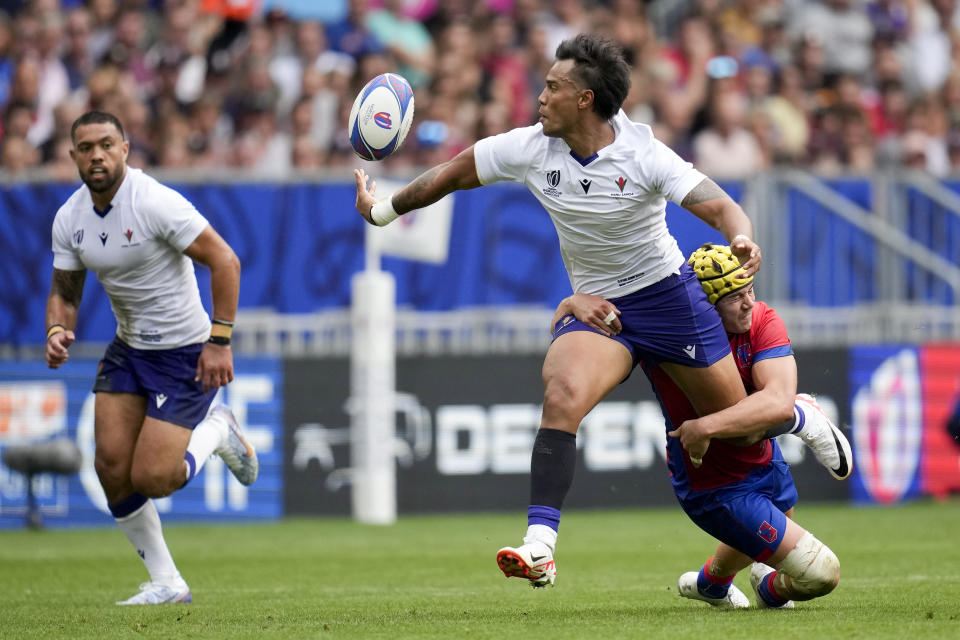 Samoa's Ulupano Junior Seuteni, center, is tackled by Chile's Matias Garafulic during the Rugby World Cup Pool D match between Samoa and Chile at the Stade de Bordeaux in Bordeaux, France, Saturday, Sept. 16, 2023. (AP Photo/Christophe Ena)