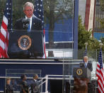 Former President George W. Bush, far right, speaks to friends and relatives of the victims of 9/11 as former first lady Laura Bush, from left, first lady Michelle Obama and President Barack Obama listen during a ceremony marking the 10th anniversary of the attacks at the National September 11 Memorial at the World Trade Center site Sunday, Sept. 11, 2011, in New York. (AP Photo/Jason DeCrow)