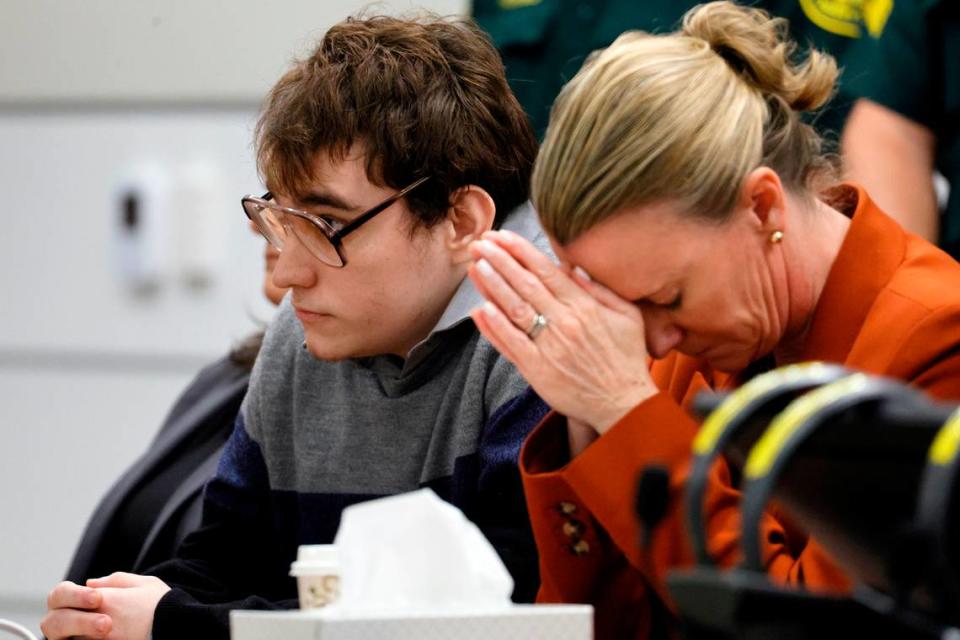 Assistant Public Defender Melisa McNeill, seated with Marjory Stoneman Douglas High School shooter Nikolas Cruz, touches her hands to her head as the last of the 17 verdicts were read in the penalty phase of Cruz’s trial at the Broward County Courthouse in Fort Lauderdale on Thursday, Oct. 13, 2022. Cruz, who pleaded guilty to 17 counts of premeditated murder in the 2018 shootings, is the most lethal mass shooter to stand trial in the U.S. He was previously sentenced to 17 consecutive life sentences without the possibility of parole for 17 additional counts of attempted murder for the students he injured that day.