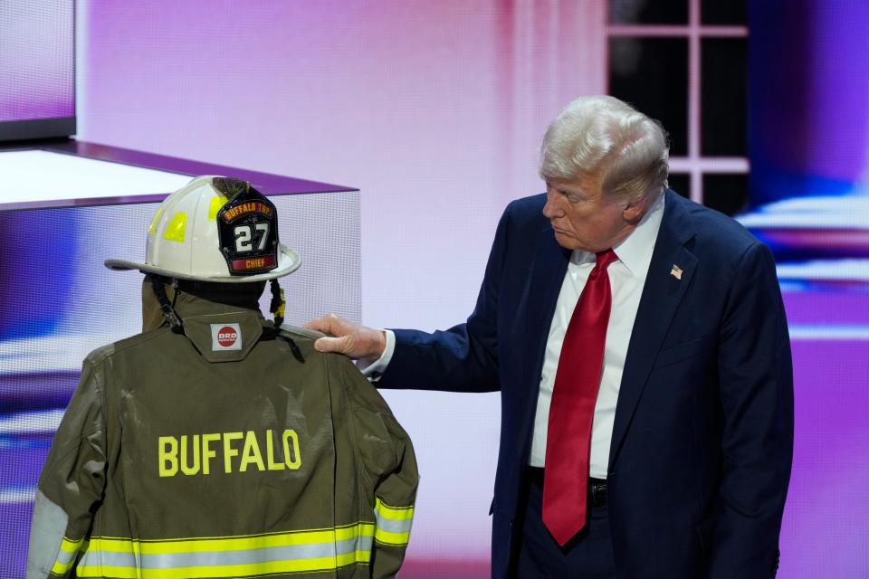 Republican presidential nominee Donald J. Trump looks at a helmet and jacket with Compertore on the back before he delivers his nomination acceptance speech during the final day of the Republican National Convention at the Fiserv Forum. The final day of the RNC featured a keynote address by Republican presidential nominee Donald Trump.