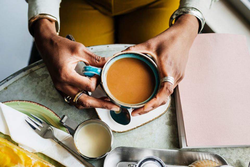 an aerial view of a woman drinking coffee while sitting at a table